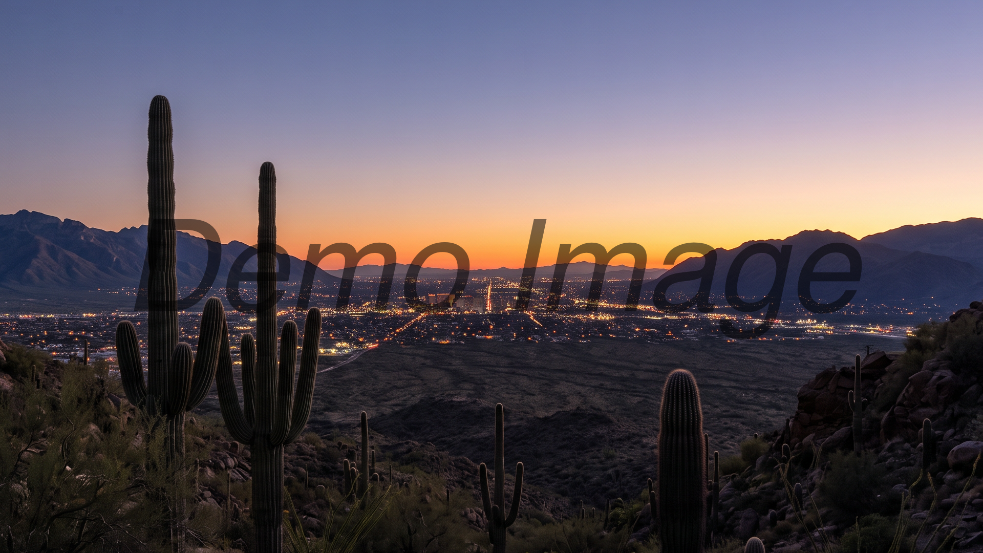 The Tucson valley at dusk from the Gates Pass overlook — the city grid lighting up between dark mountain ranges, saguaro silhouettes in the foreground, last orange light on the horizon; wide documentary landscape, arrival mood